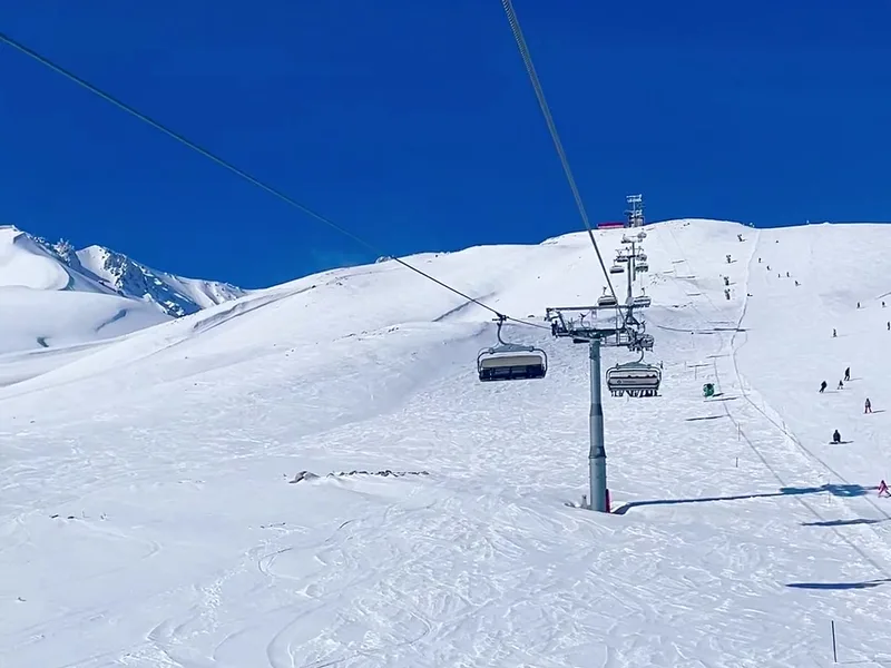 A chairlift above snowy slopes
